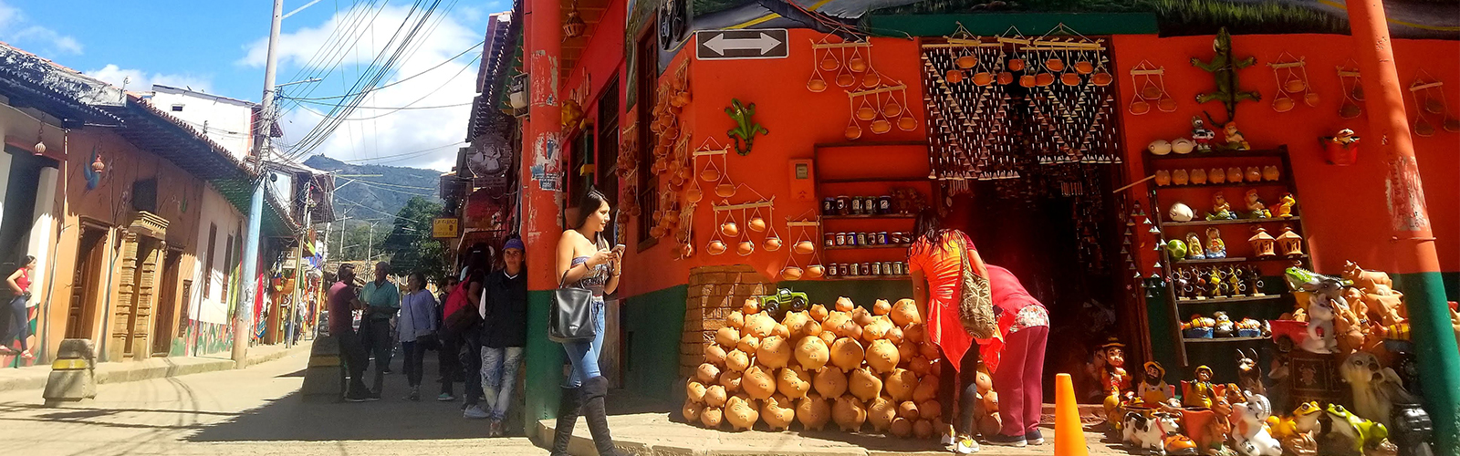 People are gathered around an outdoor market stall and looking at the products.